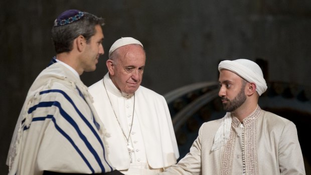 Pope Francis looks at Imam Khalid Latif, right, and Rabbi Elliot Cosgrove, left, shaking hands as he arrives for an interfaith service at the September 11 Memorial Museum in New York on Friday.