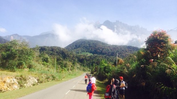 Tourists walk away from Mount Kinabalu hours after a magnitude-six earthquake shook the area.
