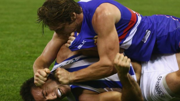 Getting to grips with each other: Liam Picken of the Bulldogs and Michael Firrito of the Kangaroos indulge in a spot of wrestling.