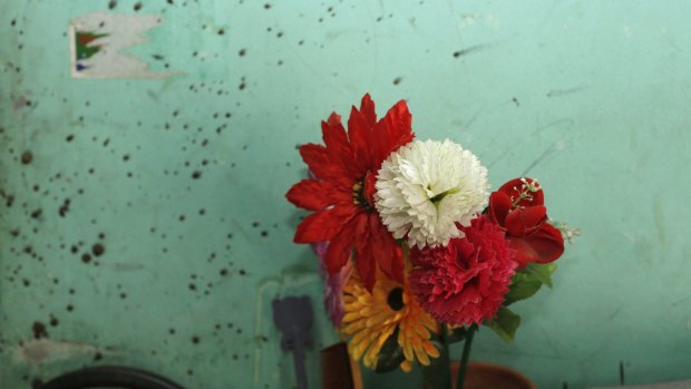 Flowers next to a blood-stained wall at the home of blogger Niloy Neel, who was hacked to death by unidentified assailants on Friday.