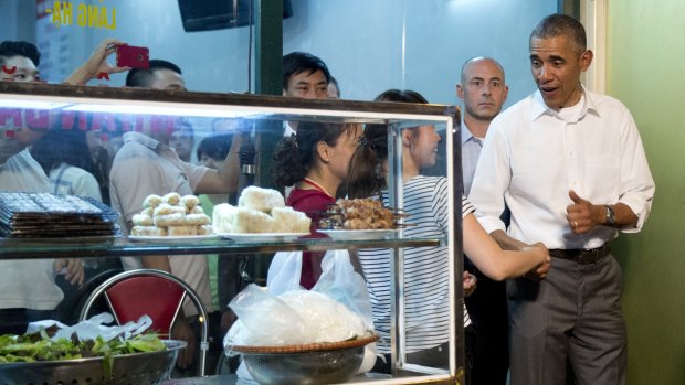 The US President greets women at the door as he walks from the Bun Cha Huong Lien restaurant.