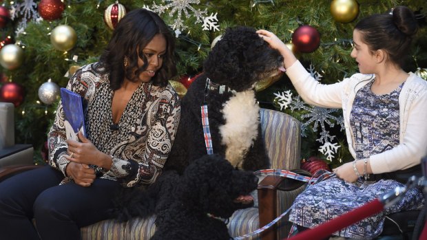 Michelle Obama, sitting next to Bo, and reading "Twas the Night Before Christmas" to a group of children in Washington last year. 
