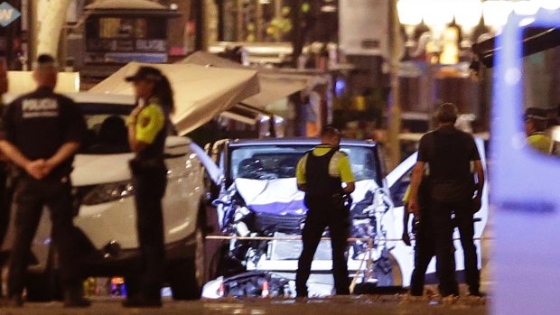 Police officers stand next to the van involved in an attack in Las Ramblas in Barcelona, Spain.