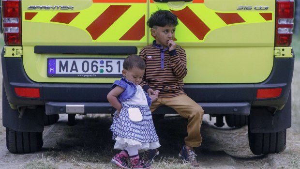 Migrant children sit on an ambulance at the Hungarian-Serbian border.