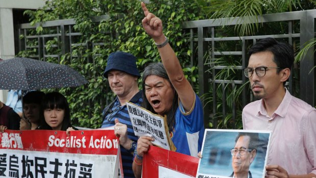 Radical pro-democracy politican Leung Kwok-hung, second from right, and other protesters holding a picture of Wukan village's leader Lin Zuluan outside the Chinese central government's liaison office in Hong Kong on Friday.