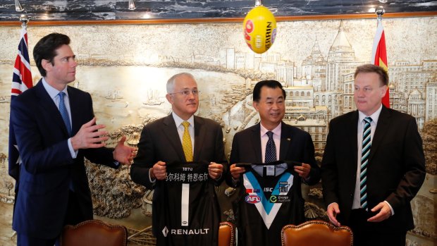 Prime Minister Malcolm Turnbull watches the ball flying past Gui Guojie, general manager of Shanghai CRED Real Estate in Shanghai. 