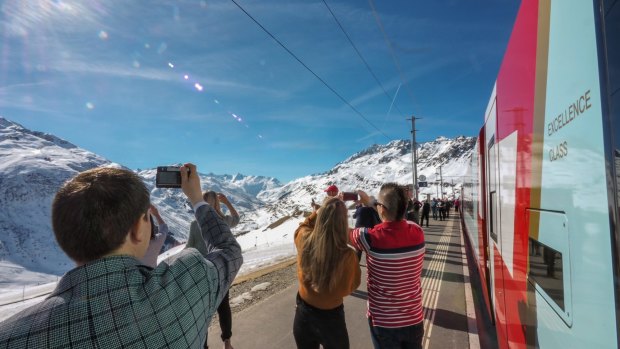 Passengers take photos from the Glacier Express, Switzerland.