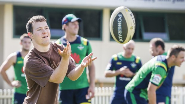 Branch Out Disability Services participant Tim Carr kicks the ball around with Canberra Raiders players at Raiders HQ.