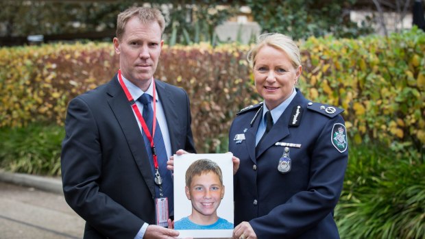International Missing Children's Day family spokesperson Michael Macintosh, in Canberra with an age-progressed photograph of his missing son Mathieu-Pierre Macintosh, who would now be 13, with Australian Federal Police Assistant Commissioner Debbie Platz, National Manager Crime Operations.