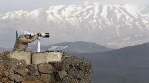 A member of the United Nations Disengagement Observer Force (UNDOF) looks through binoculars at Mount Bental, an observation post in the Israeli occupied Golan Heights. A UN peacekeeper was killed by cross-border shelling between Israel and Hezbollah.