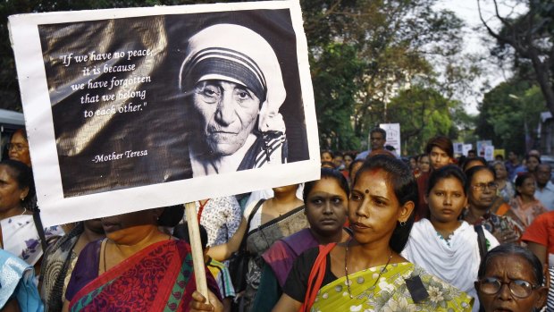 A woman holds a poster of Mother Teresa during a vigil. Christians in India said on Monday that the Hindu nationalist government of Narendra Modi had not done enough to protect their religion after a spate of attacks. 