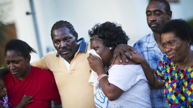 Gary and Aurelia Washington, centre left and right, the son and granddaughter of Ethel Lance who died in the shooting, are comforted by fellow family members.