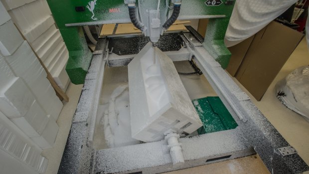 The CNC machine in action, carving a size 18 body from a block of foam.