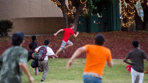 Protesters against Donald Trump chase a man leaving a Trump campaign rally in California.