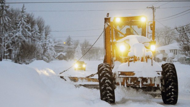 Snow is cleared from the road in Lancaster, New York, on Wednesday.