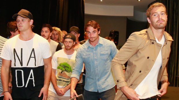 Bombers captain Jobe Watson flanked by teammates including Michael Hurley (left), Travis Colyer and Tom Bellchambers (right) leave after speaking to the media.