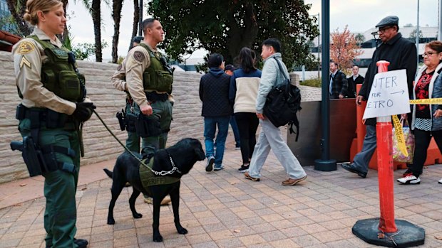 Los Angeles police stand guard as commuters arrive at the Universal City Red Line station in Los Angeles.