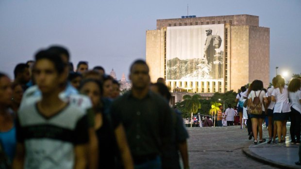 A photograph of the late Fidel Castro hangs on a building in Revolution Plaza, Havana, where people wait in line to pay their last respects on Monday.