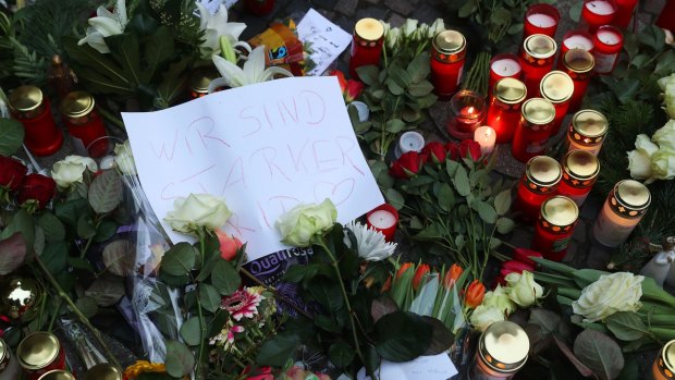 A message reading "We are stronger" sits among flowers near the scene of the Berlin attack.