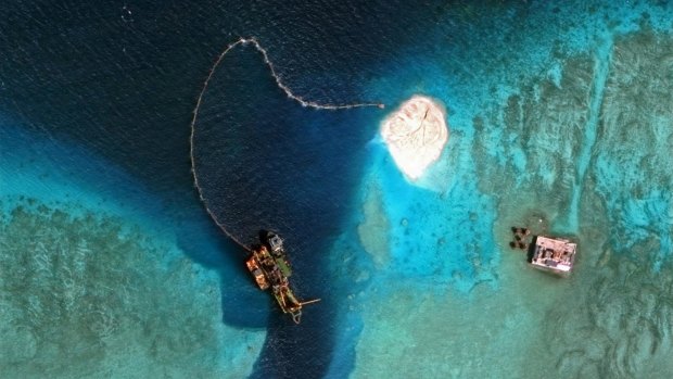 A dredger operates at the southern entrance to the Mischief Reef. China says new islands in the disputed South China Sea will provide military defence and civilian services.