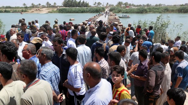 Iraqis rest at the bridge as they flee their hometown of Ramadi, 65 kilometres west of Baghdad.