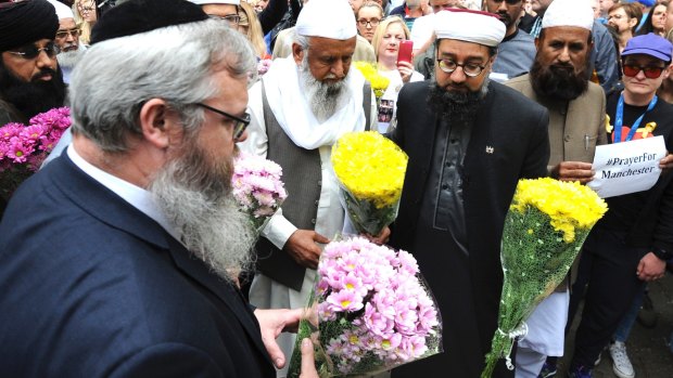 Members of the British Muslim Forum and religious leaders from Christian and Jewish faiths pay their respects at St Ann's square in Manchester on Sunday.