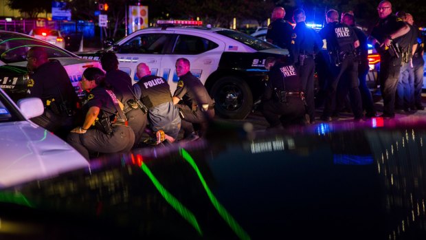Dallas police officers take cover during the attack.