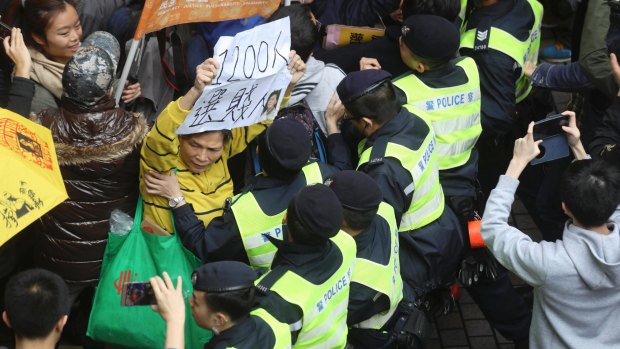 Protesters scuffle with police officers during a protest against the chief executive election in Hong Kong.