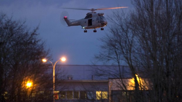 A helicopter flies over the printing plant after police stormed the building.