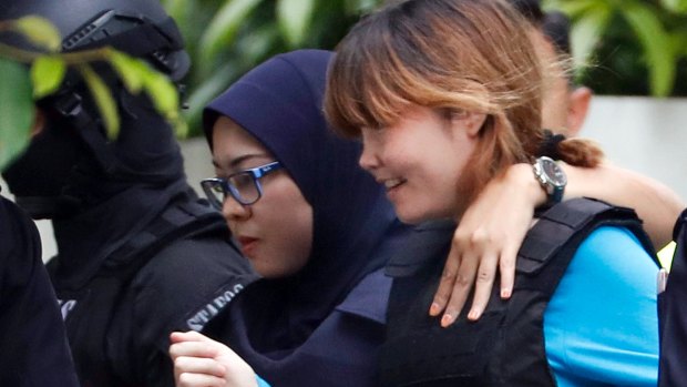 Vietnamese suspect Doan Thi Huong, right, arrested in the death of Kim Jong Nam, is escorted by police officers as she leaves a court house in Sepang, Malaysia, on Thursday.