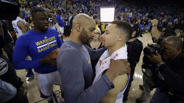 Golden State Warriors' Stephen Curry, right, is hugged by Memphis Grizzlies' Vince Carter  at the end of a 125-104 record-breaking Warriors win.