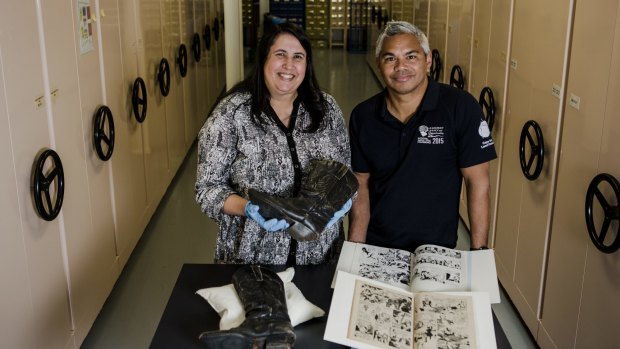 The Australian Institute of Aboriginal and Torres Strait Islander Studies Curator Alana Garwood-Houng and community engagement officer John-Paul Janke with cowboy boots worn by Deborah Mailman and a Phantom comic book translated into Warlpiri.