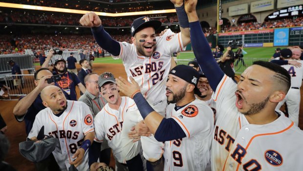 Party time: Jose Altuve is chaired off the field by teammates after Houston defeated the Yankees in game seven last week.