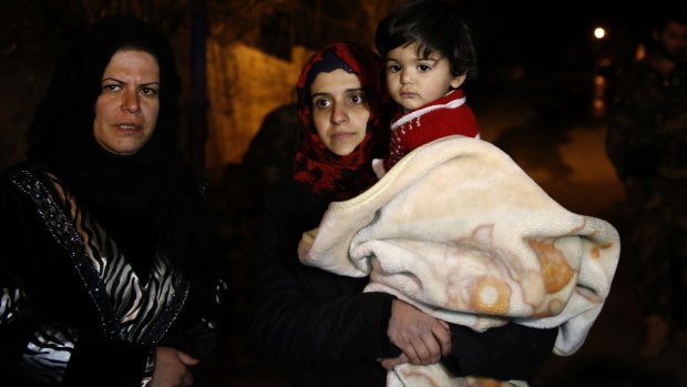 People wait to leave the besieged town of Madaya, north-west of Damascus, in January.