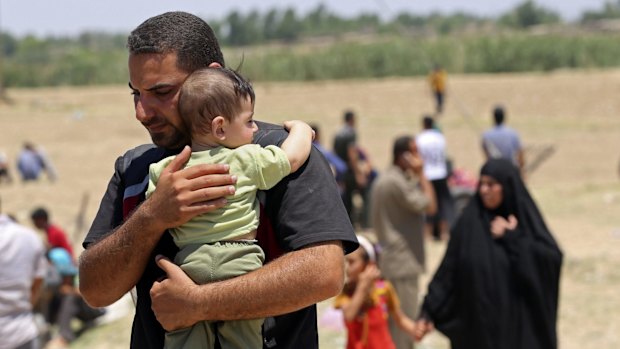 Displaced Iraqis from Ramadi cross the Bzebiz bridge after spending the night walking towards Baghdad.