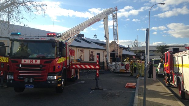 Firefighters attempt to reach the man on top of the Fremantle Markets roof. 