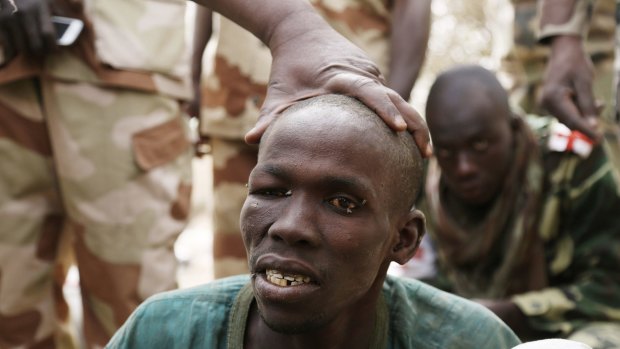 A man, whom the Chadian military say they have taken prisoner for belonging to Islamist group Boko Haram, is seen in Gambaru on Thursday.