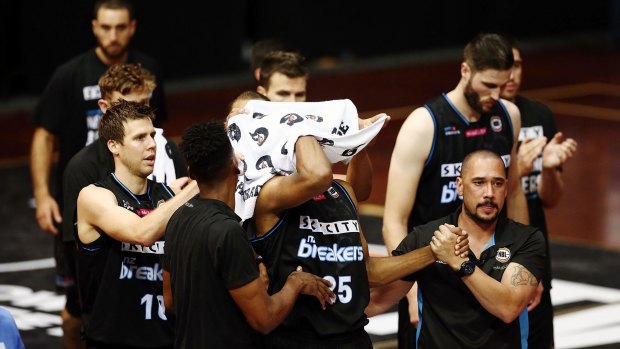 Breakers players applaud Akil Mitchell as he is helped off the court after suffering a serious eye injury.