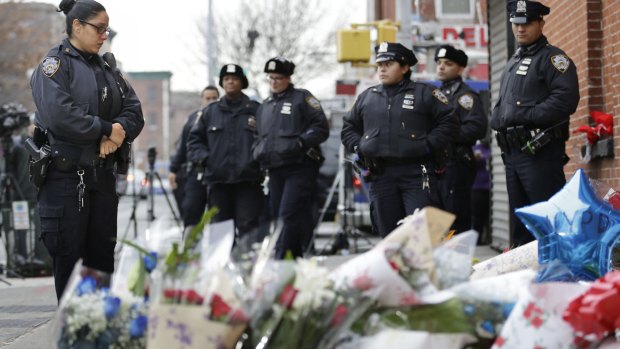 Police officers pay their respects near where New York City police officers Rafael Ramos and Wenjian Liu were murdered.