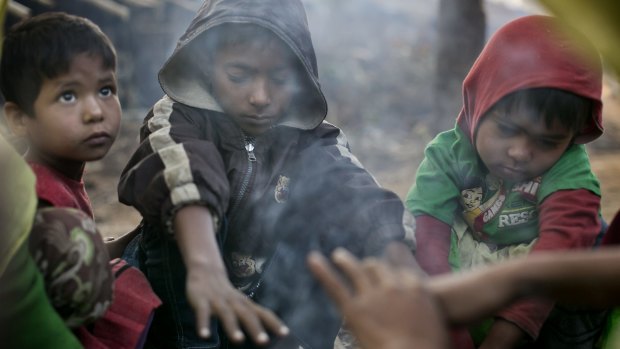A family who fled violence in Salipara village in Myanmar sit at a Rohingya refugee camp in Bangladesh.