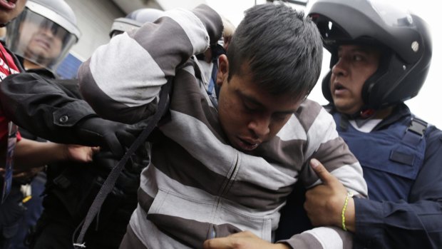 Detained: Riot police arrest a demonstrator near the Benito Juarez International Airport in Mexico City.