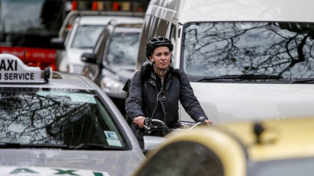 A cyclist in traffic in Melbourne's CBD.