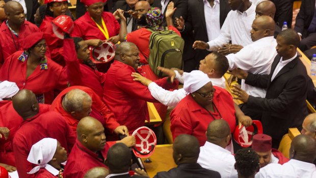 Far left Economic Freedom Fighters, wearing red, clash with security during the South African President's State of the Nation address.