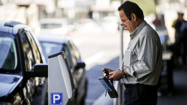 A parking inspector checks cars in Yarraville in November.