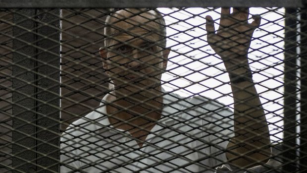 Australian Al Jazeera journalist Peter Greste hears the verdict from inside the defendents' cage.