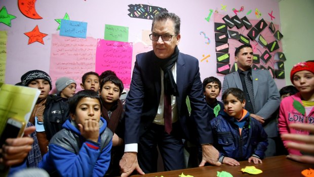 German Minister for Economic Co-operation and Development Gerd Mueller with Syrian refugee children during his visit to Baqaa Refugee Camp in Amman, Jordan, on Tuesday.