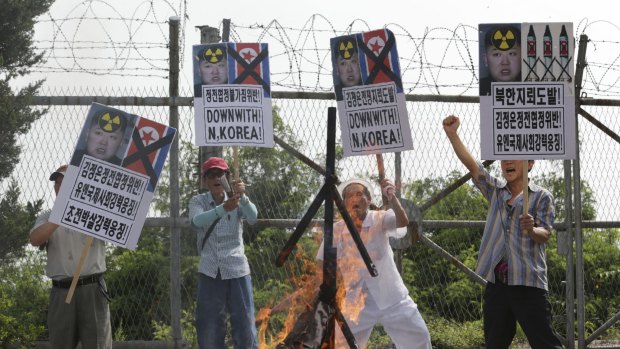 South Korean conservatives shout slogans after burning an effigy of North Korean leader Kim Jong-un and North Korean flags during a rally in August. 