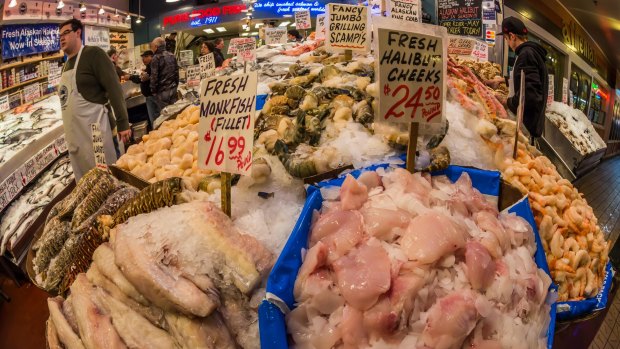 Fresh seafood, including halibut cheeks and monkfish fillets, for sale in the Pike Place Market.