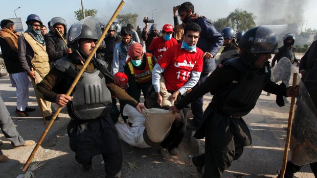 A protester is carried off by police, who have attempted to disperse a blockade of a main route into Islamabad. 