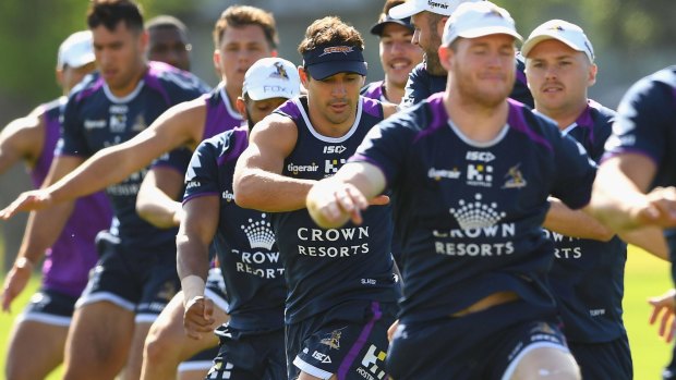The long road back: Billy Slater (in the blue cap) joins his Storm teammates at training in December.